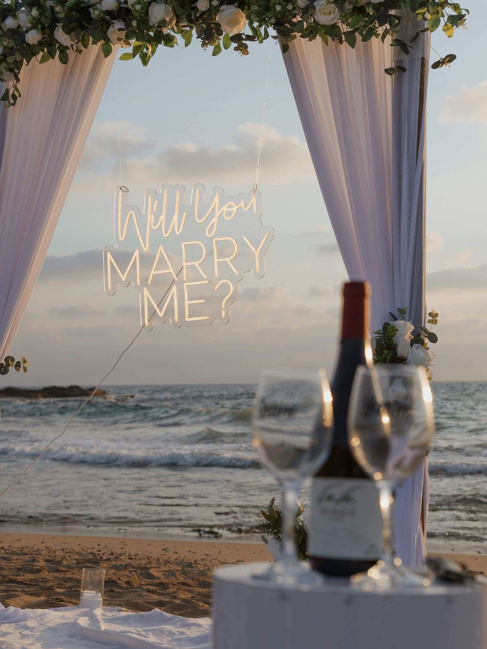 Romantic proposal setup arranged on a beach at sunset